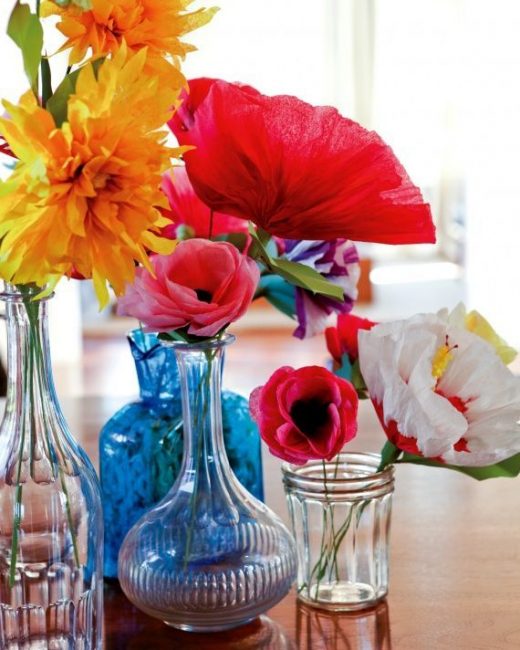 Flores multicoloridas em recipientes de vidro