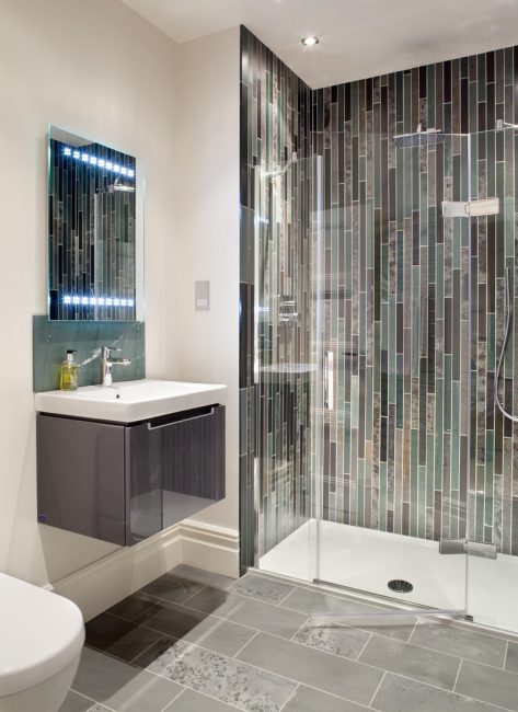 Mosaico com azulejos oblongos em um design vertical ajudará a ampliar o espaço visualmente para cima.