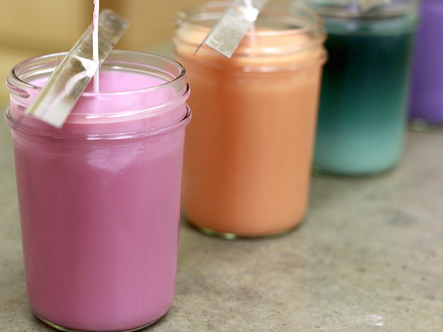 Velas em cores diferentes em latas
