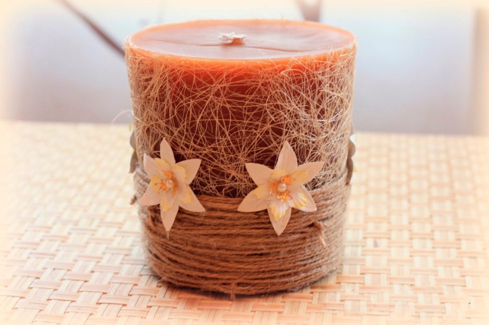 Decore a vela acabada com uma corda e flores
