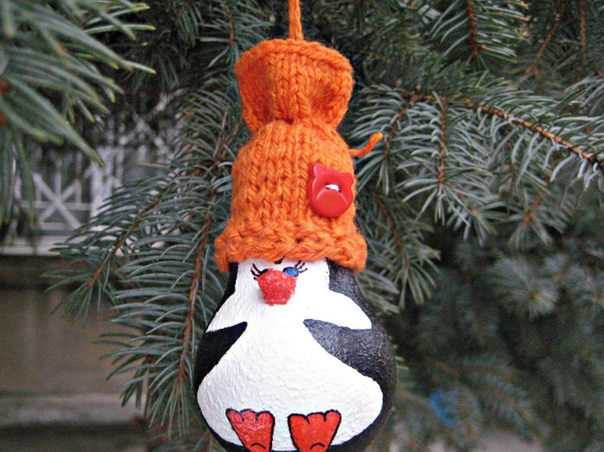 Um pinguim maravilhoso de uma lâmpada em uma árvore de Natal